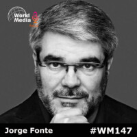 Retrato en blanco y negro de Jorge Fonte, presentador del podcast World Media, con un fondo gris y el logotipo del programa en la esquina superior izquierda.